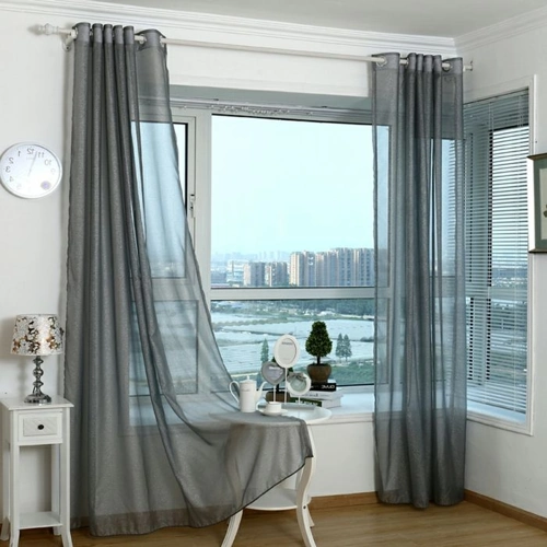 Sheer gray window curtains add a touch of elegance to a modern living space