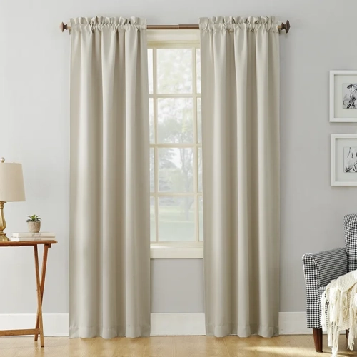 Thermal Blackout Rod Pocket Window Curtains in a neutral beige tone, hanging gracefully on a window in a living room setting