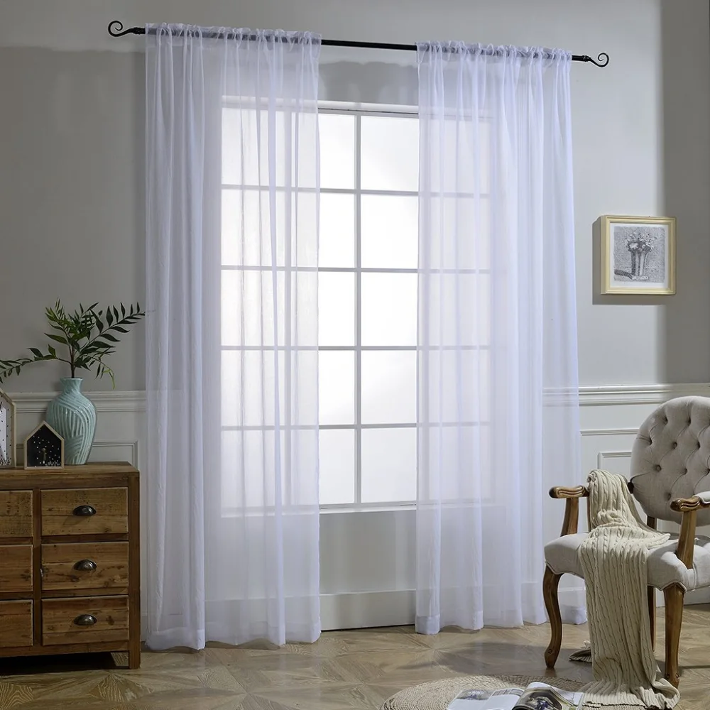 white sheer curtains hang gracefully on a window, allowing soft light to filter through